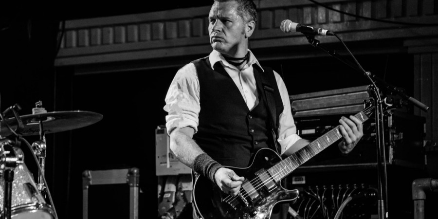 Black and white image of Mat Howlett playing guitar
